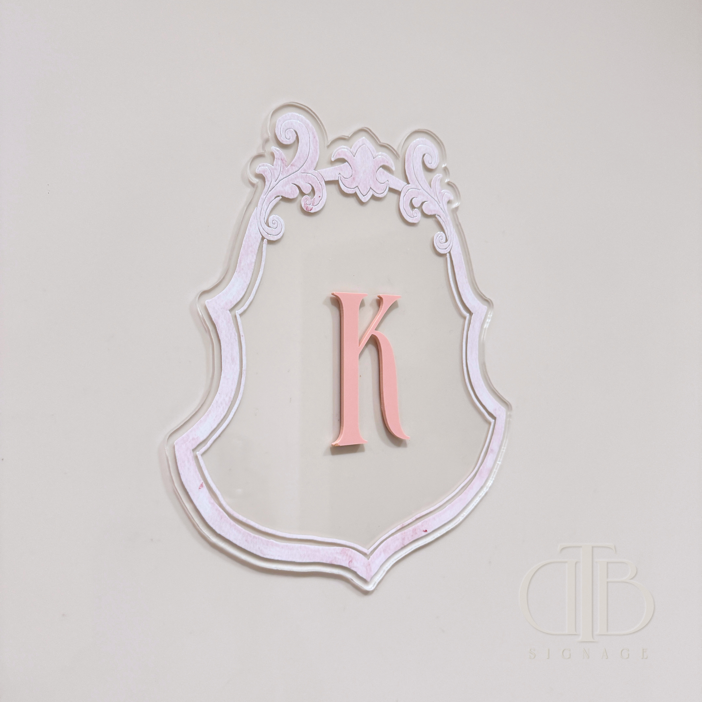 Luxury crest with baby pink frame UV printed and acrylic initial K in baby pint, left side view