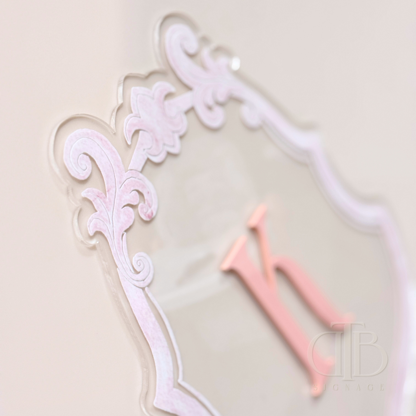 Luxury crest with baby pink frame UV printed and acrylic initial K in baby pint, close up view of the frame showing raised effect of the UV print