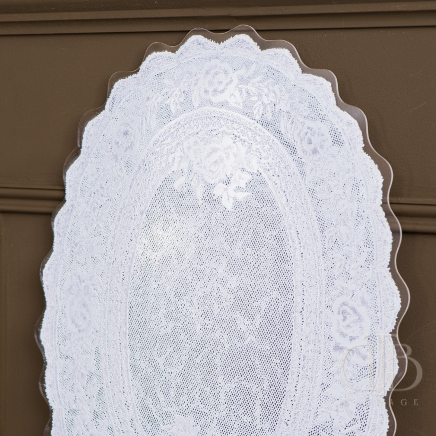 Set of white lace doilies acrylic signage on a brown background
