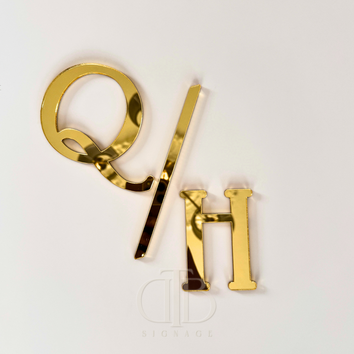 Gold letters 'Q/H' on a white background
