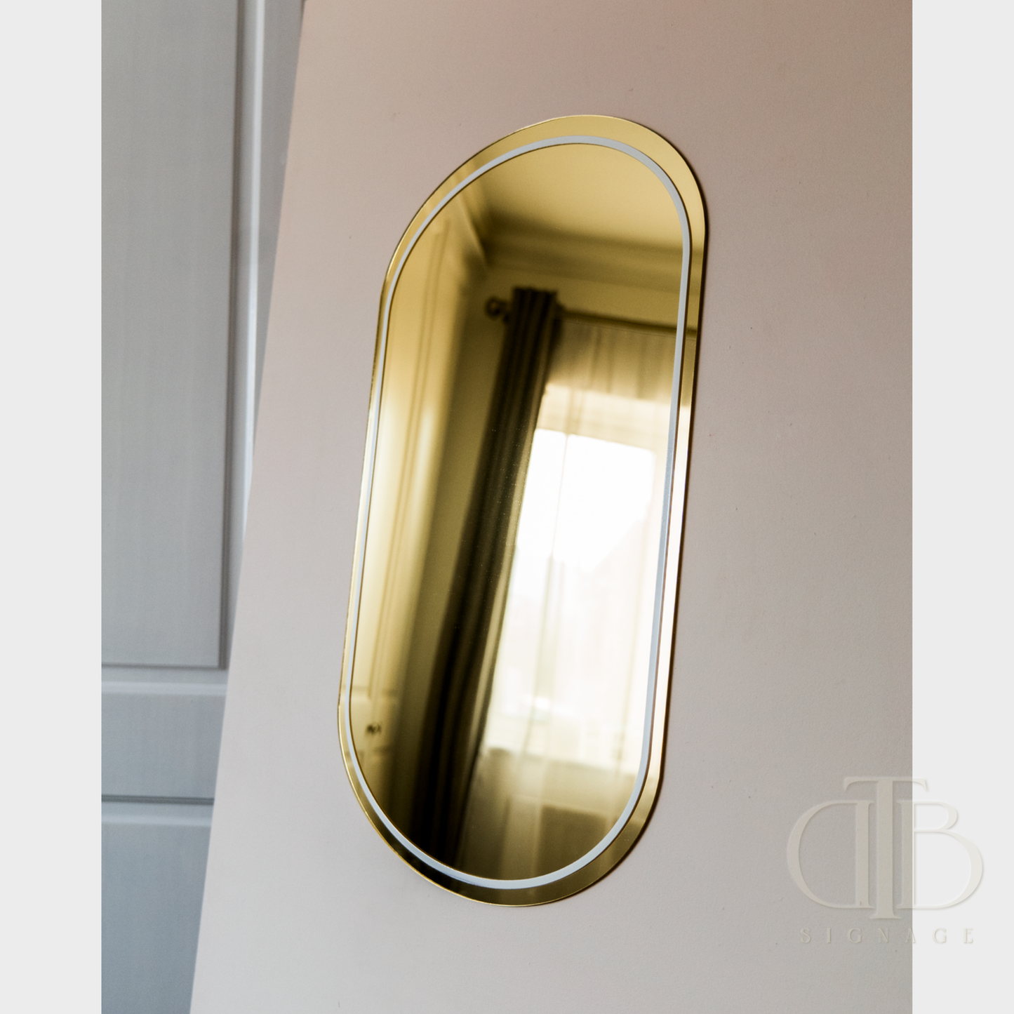Gold-framed oval mirror on a light-colored wall
