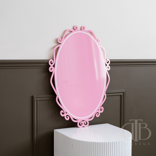Pink decorative acrylic signage on a white pedestal against a gray wall