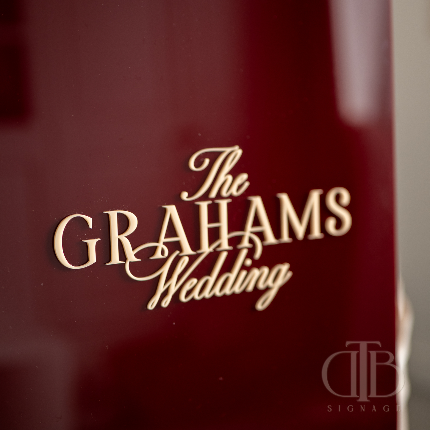 Close-up of a red product with 'The Grahams Wedding' text in gold on a blurred background.