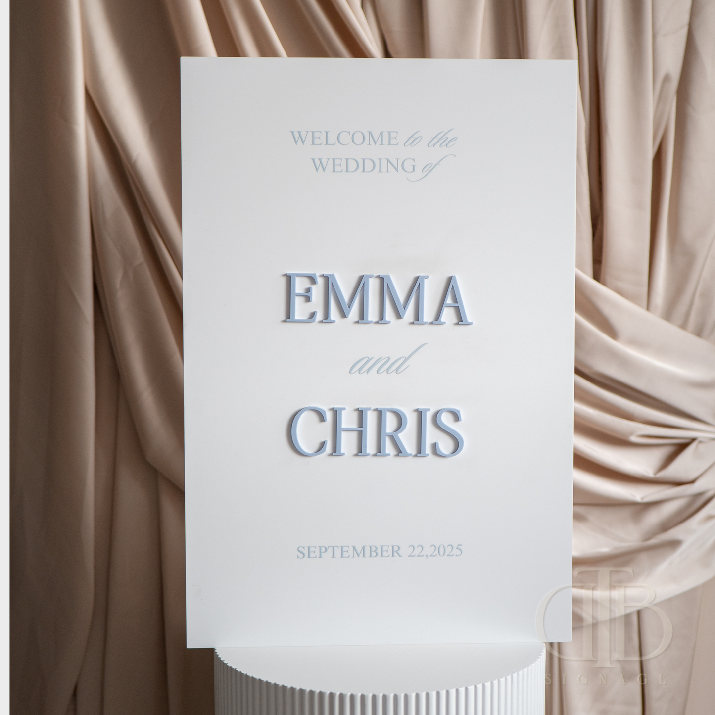 Wedding welcome sign with 'Emma and Chris' on a draped fabric background