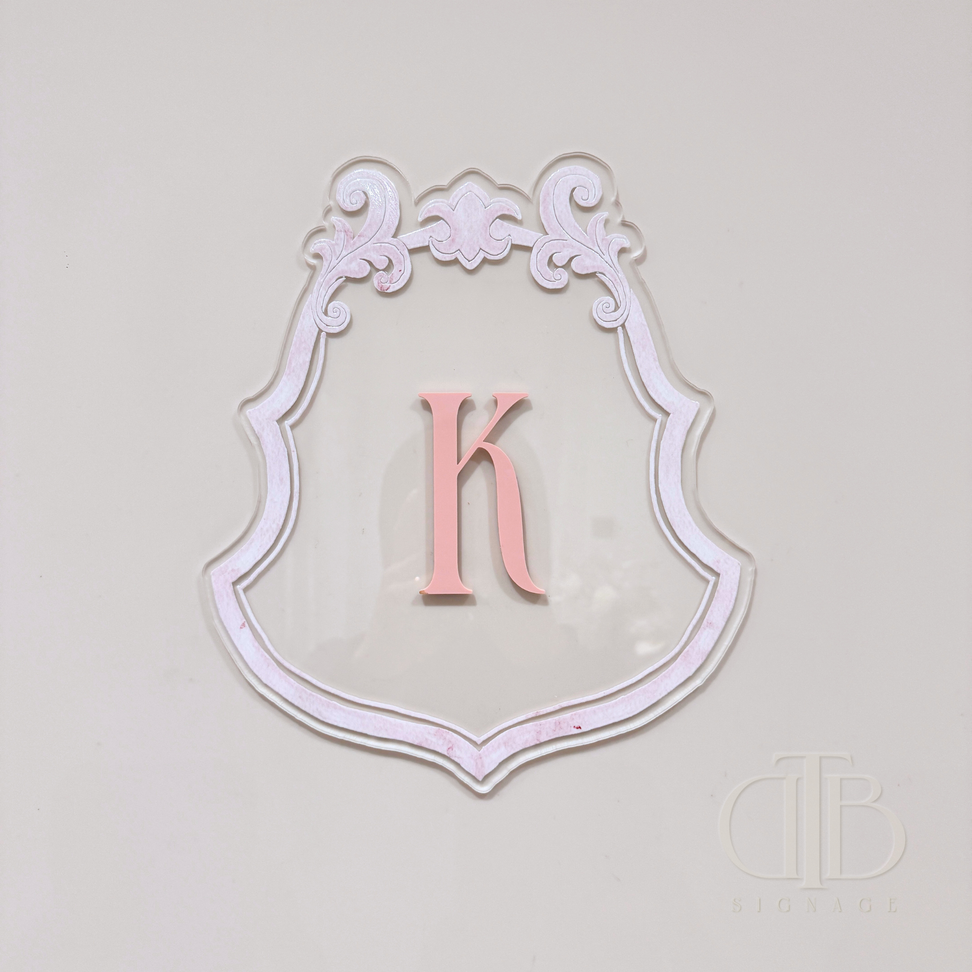 Luxury crest with baby pink frame UV printed and acrylic initial K in baby pint, front view