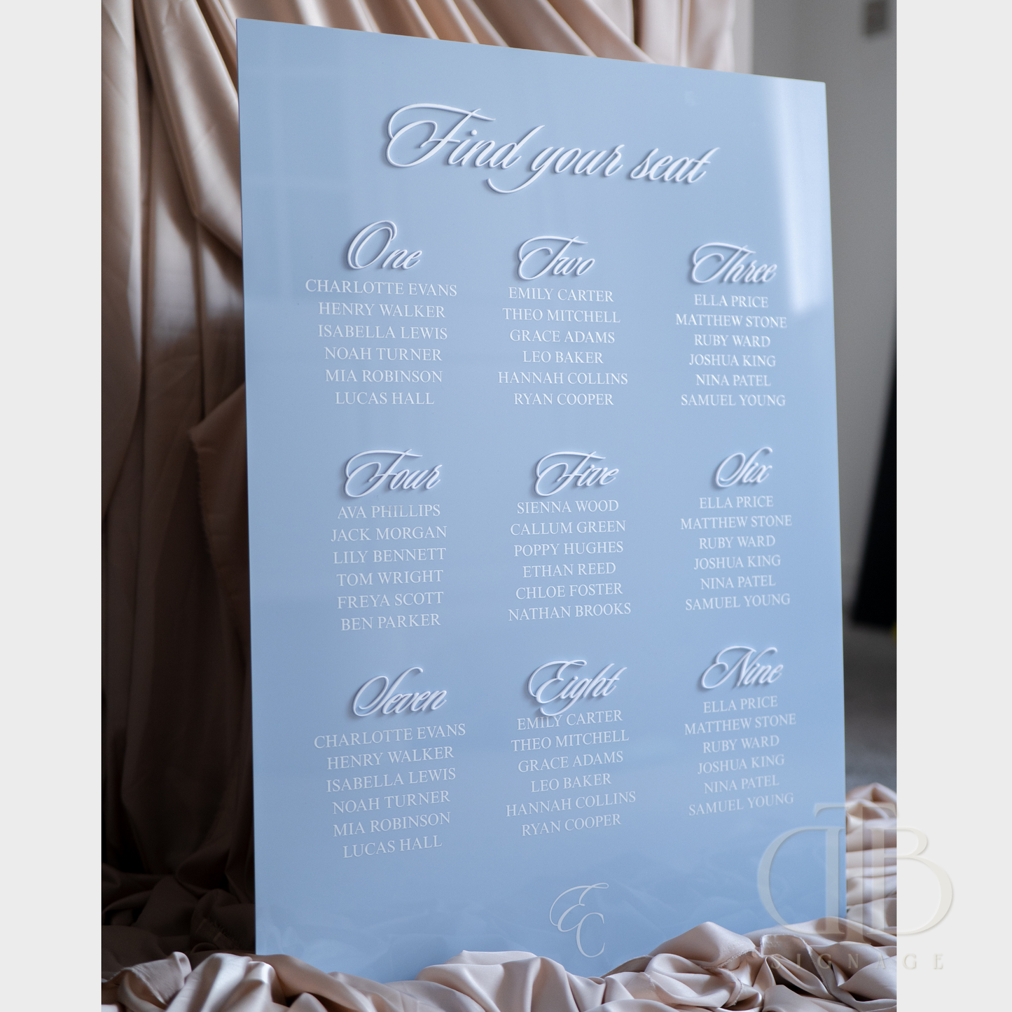 Light blue seating chart for an event with names and numbers.