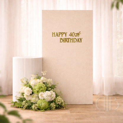 Floral arrangement on a wooden floor with a 'Happy 40th Birthday' sign on a beige wall.