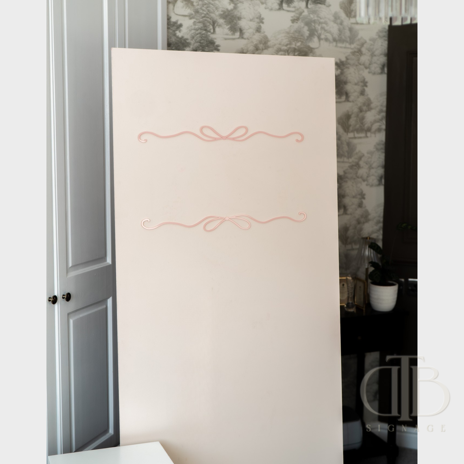 Beige board with decorative pink design on a room interior background