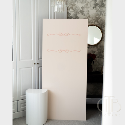 Beige partition with decorative elements in a room with patterned wallpaper and a white cabinet.