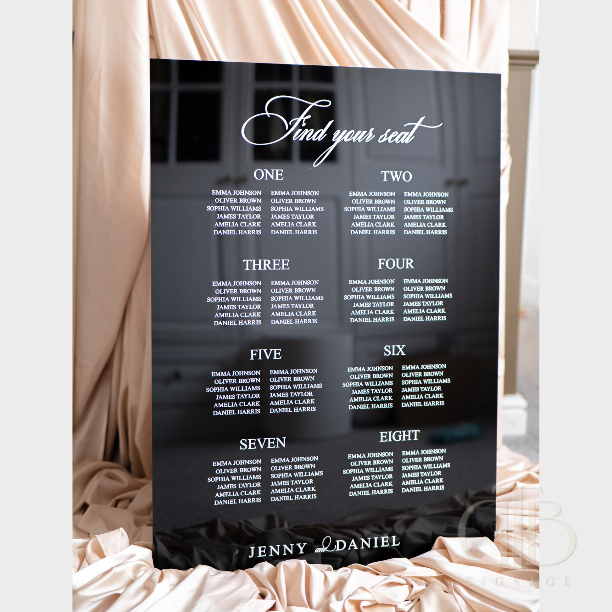 Seating chart for an event with names and numbers on a black background, featuring the brand 'Jenny Daniel'.