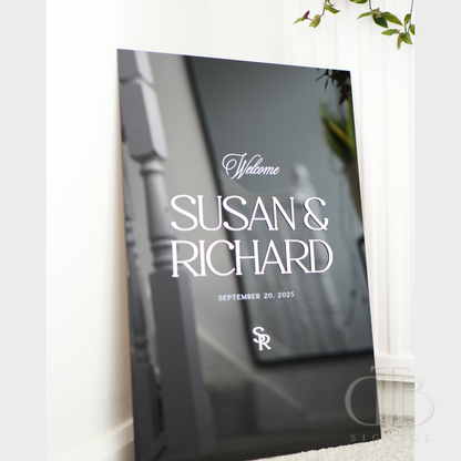 Decorative sign with 'Welcome SUSAN & RICHARD' text on a blurred background