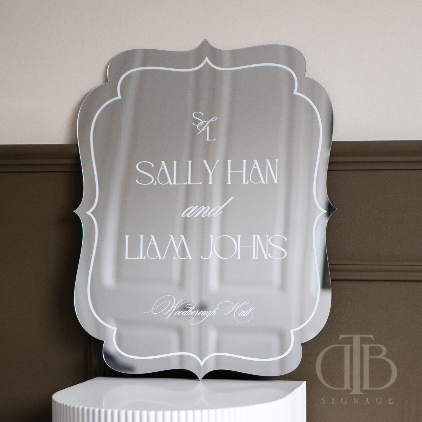 Decorative mirror with 'Sally Han and Liam Johns' text on a neutral background