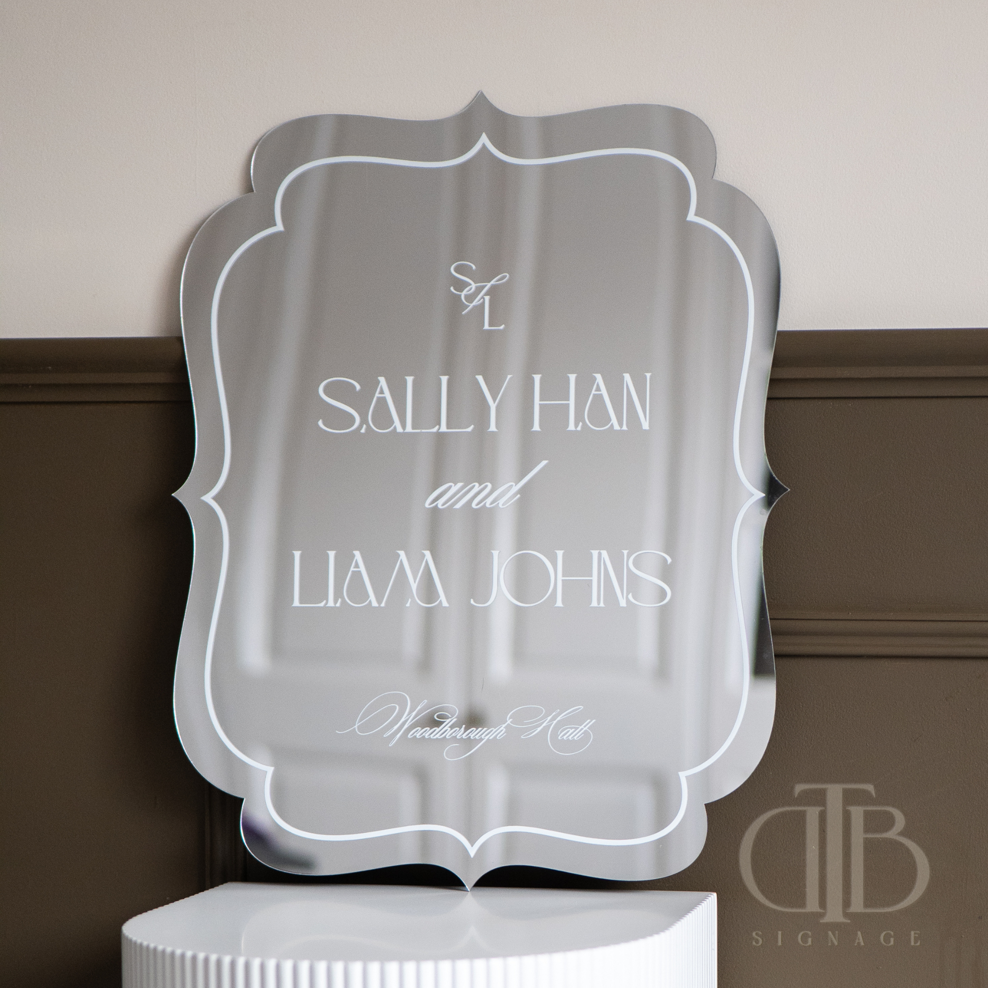 Decorative mirror with 'Sally Han and Liam Johns' text on a neutral background