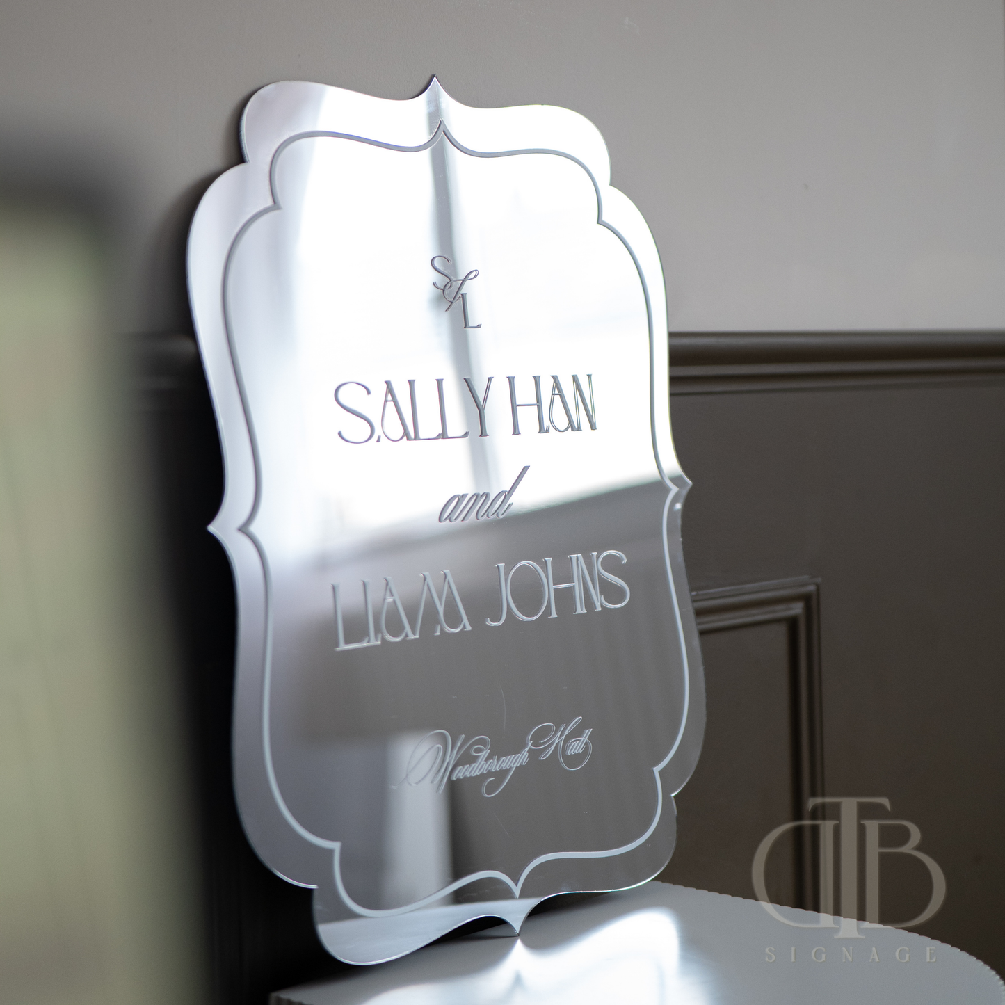 Decorative mirror with engraved text on a neutral background