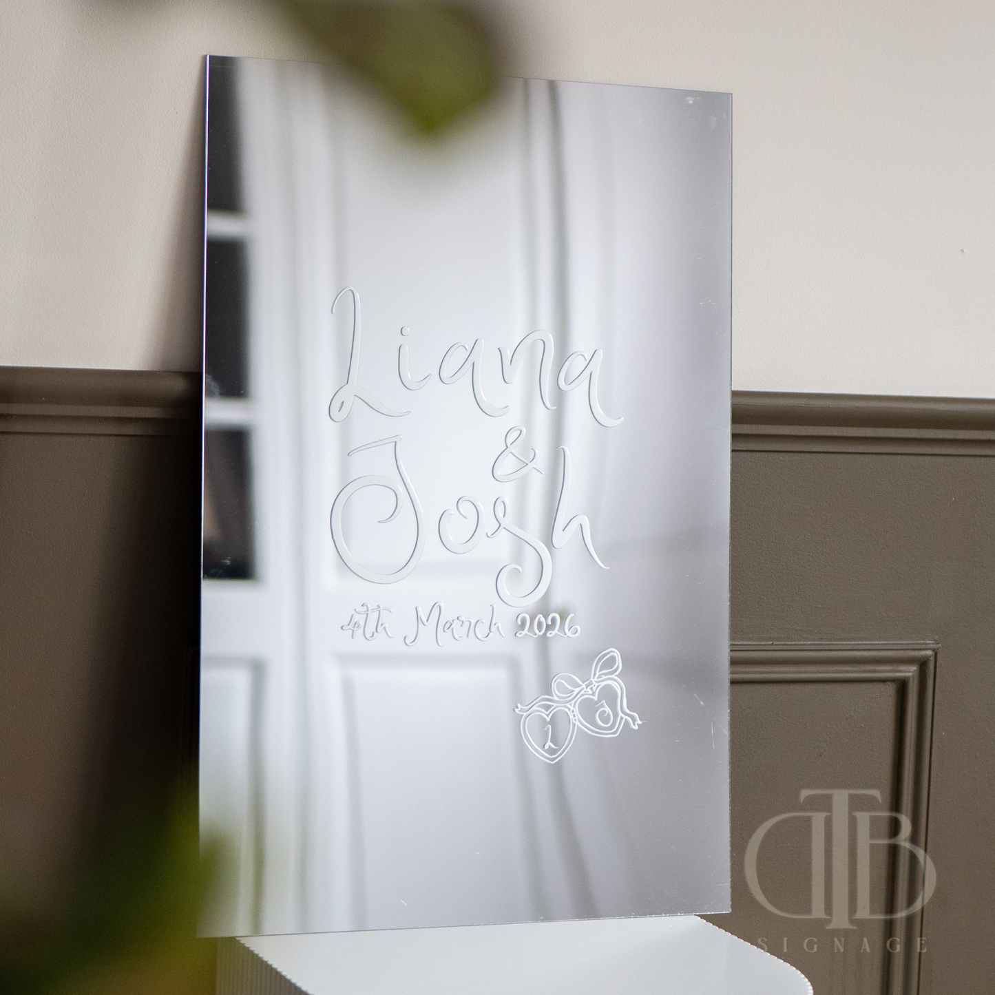 Decorative mirror with engraved text and design on a neutral background
