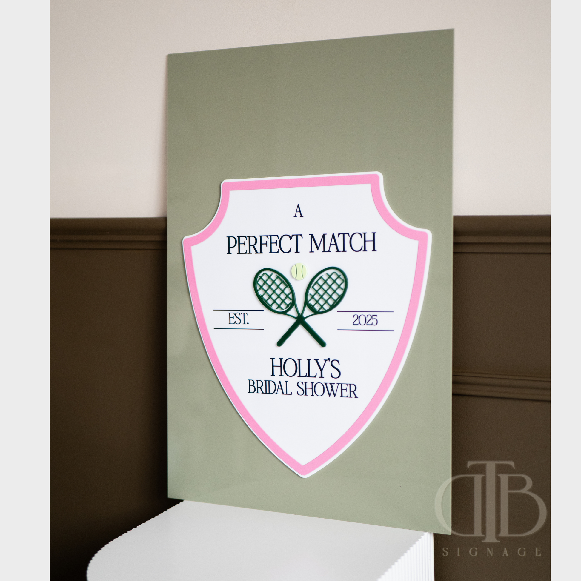 Decorative sign for a bridal shower with tennis racket design on a green background