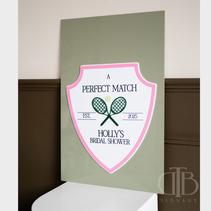 Decorative sign for a bridal shower with tennis racket design on a green background