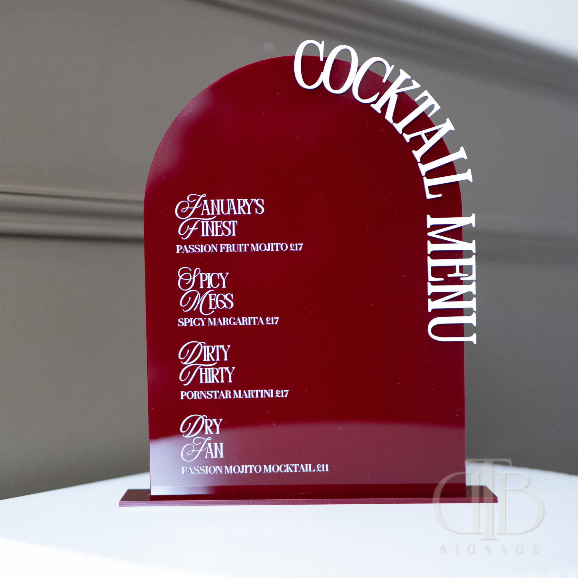 Red cocktail menu with white text on a gray background