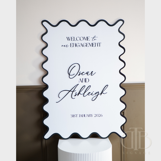 Decorative sign for an engagement event with personalized text on a white background.