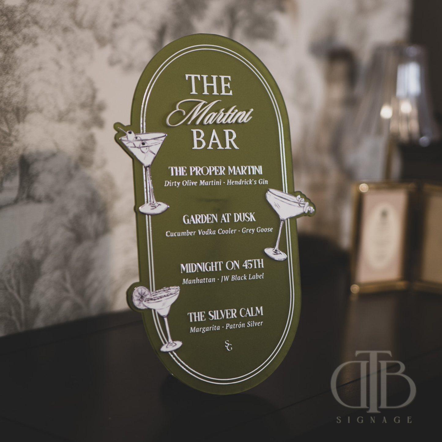 Green cocktail menu sign with drink names and descriptions on a blurred background