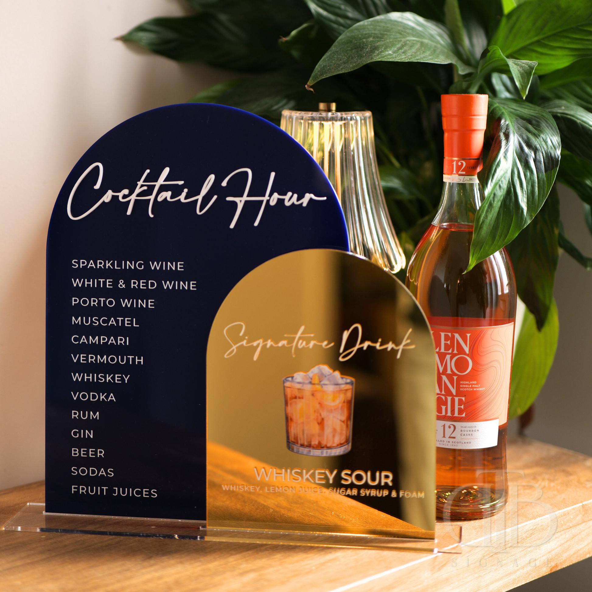 Bottle of Glenmorangie whiskey with a cocktail hour menu on a wooden surface.