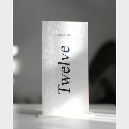 White table number card with 'Table No. Twelve' text on a gray background