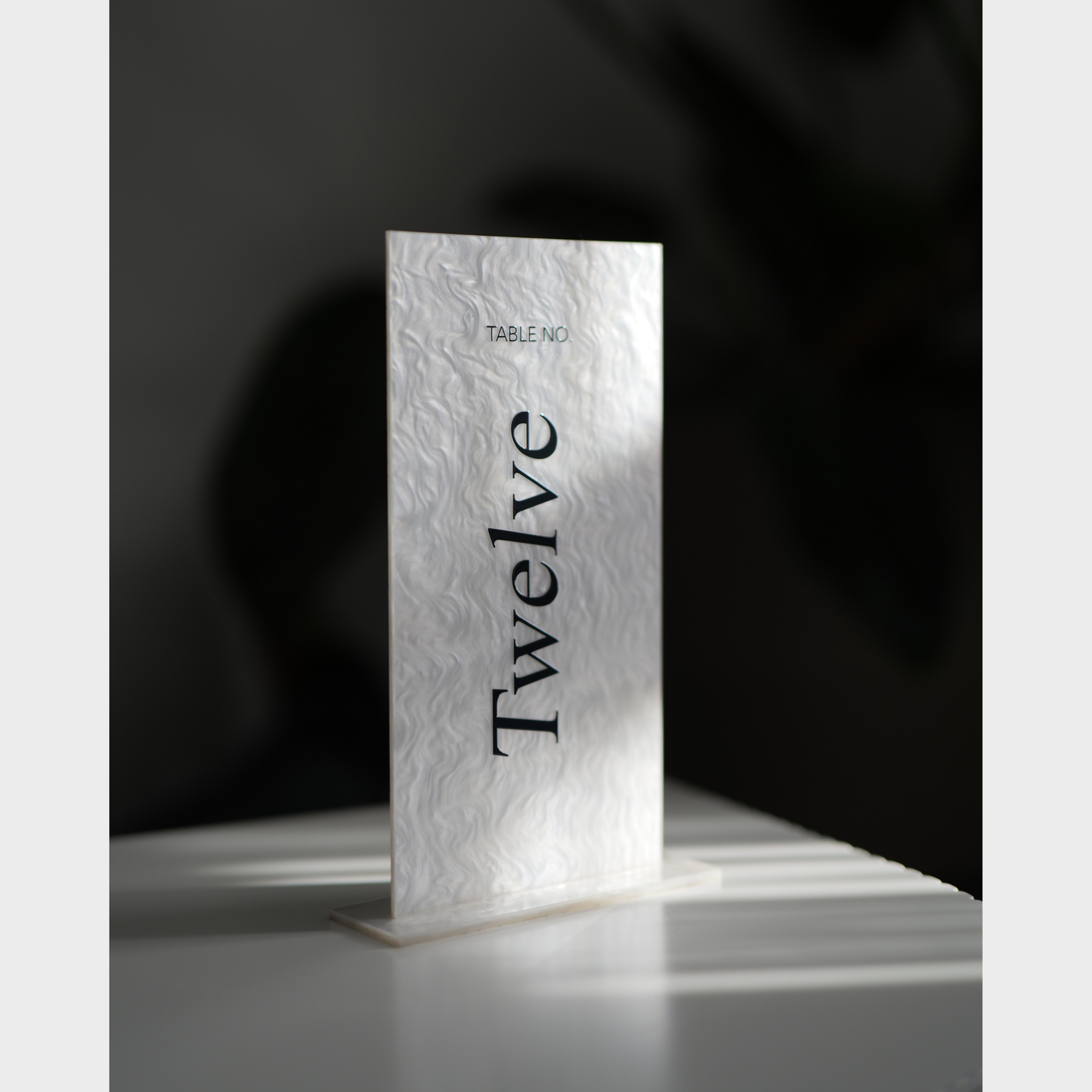 Marble-textured table number card with 'Twelve' on a dark background