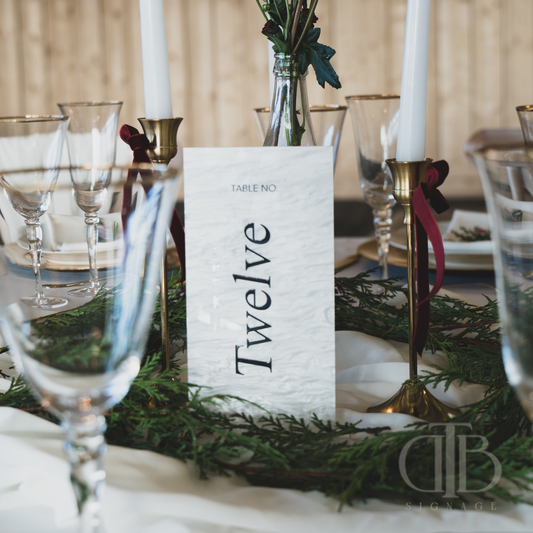 Table setting with a 'Twelve' table number card and festive decorations.