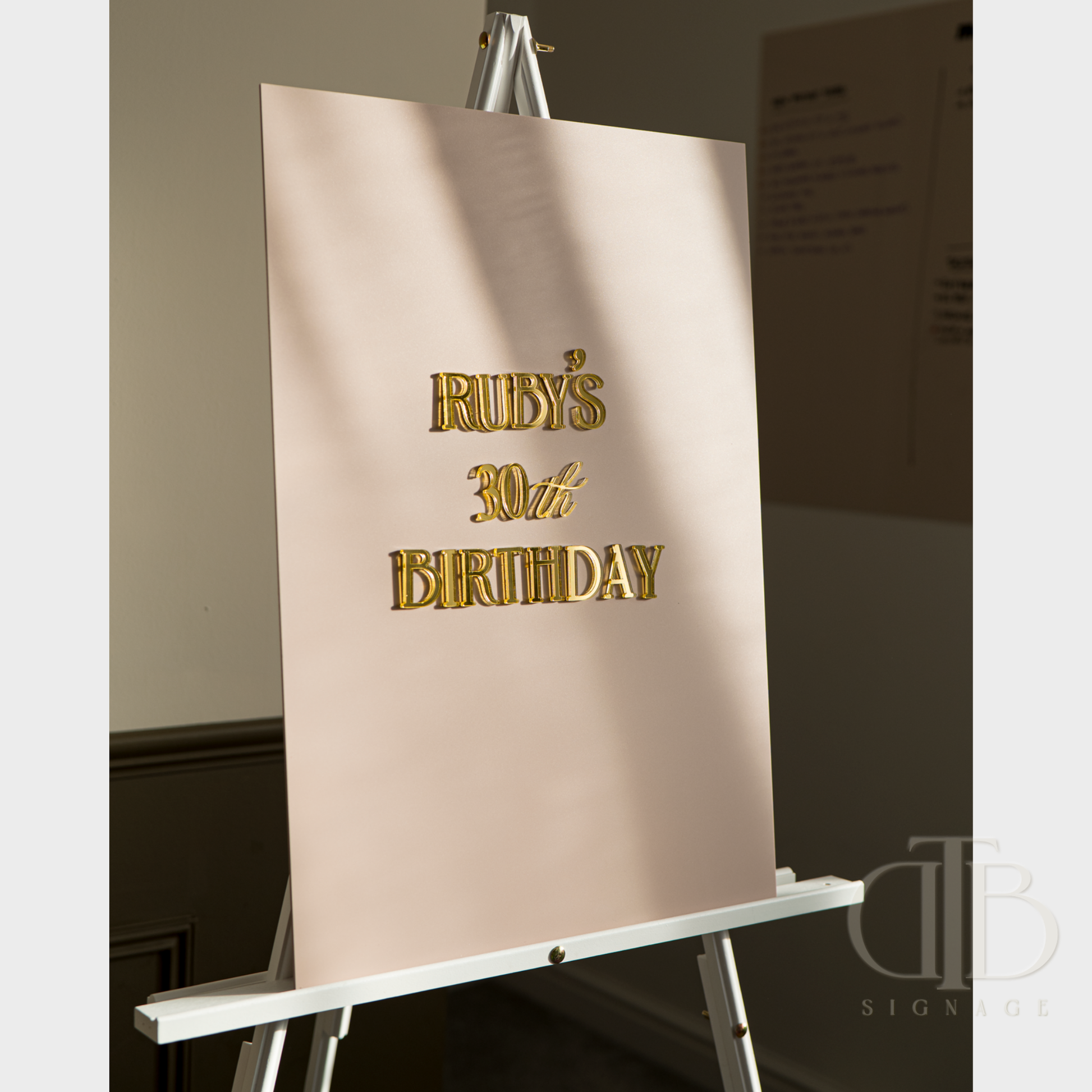 Beige backdrop with 'Ruby's 30th Birthday' text on an easel