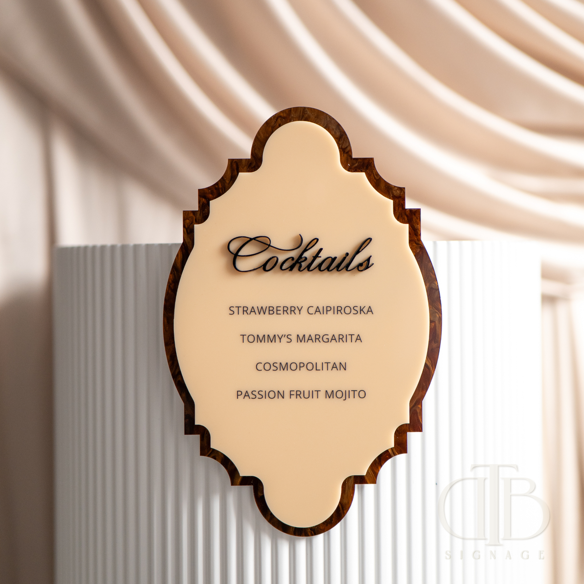Decorative cocktail menu with wooden frame against a draped fabric background