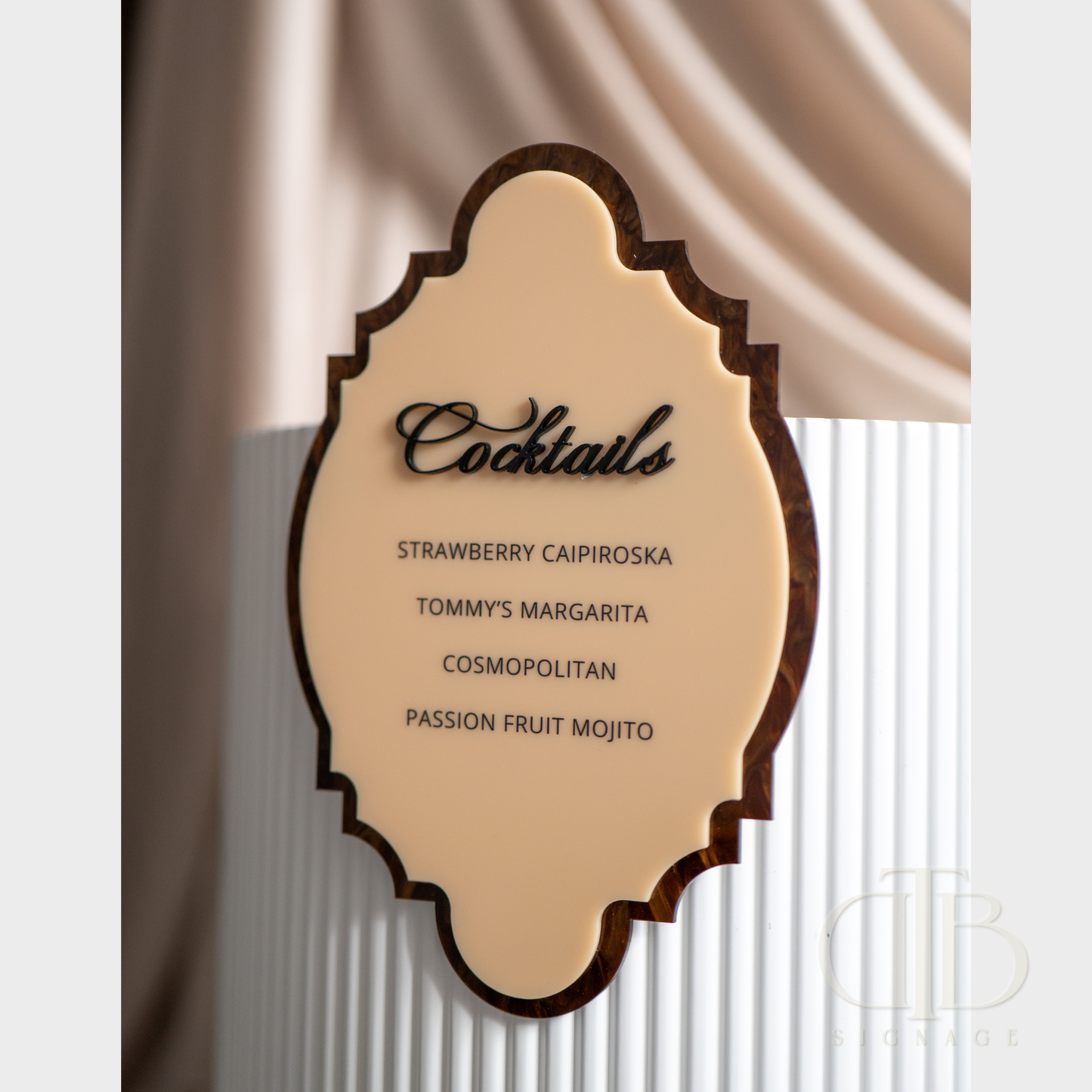Decorative cocktail menu with wooden frame against a draped fabric background
