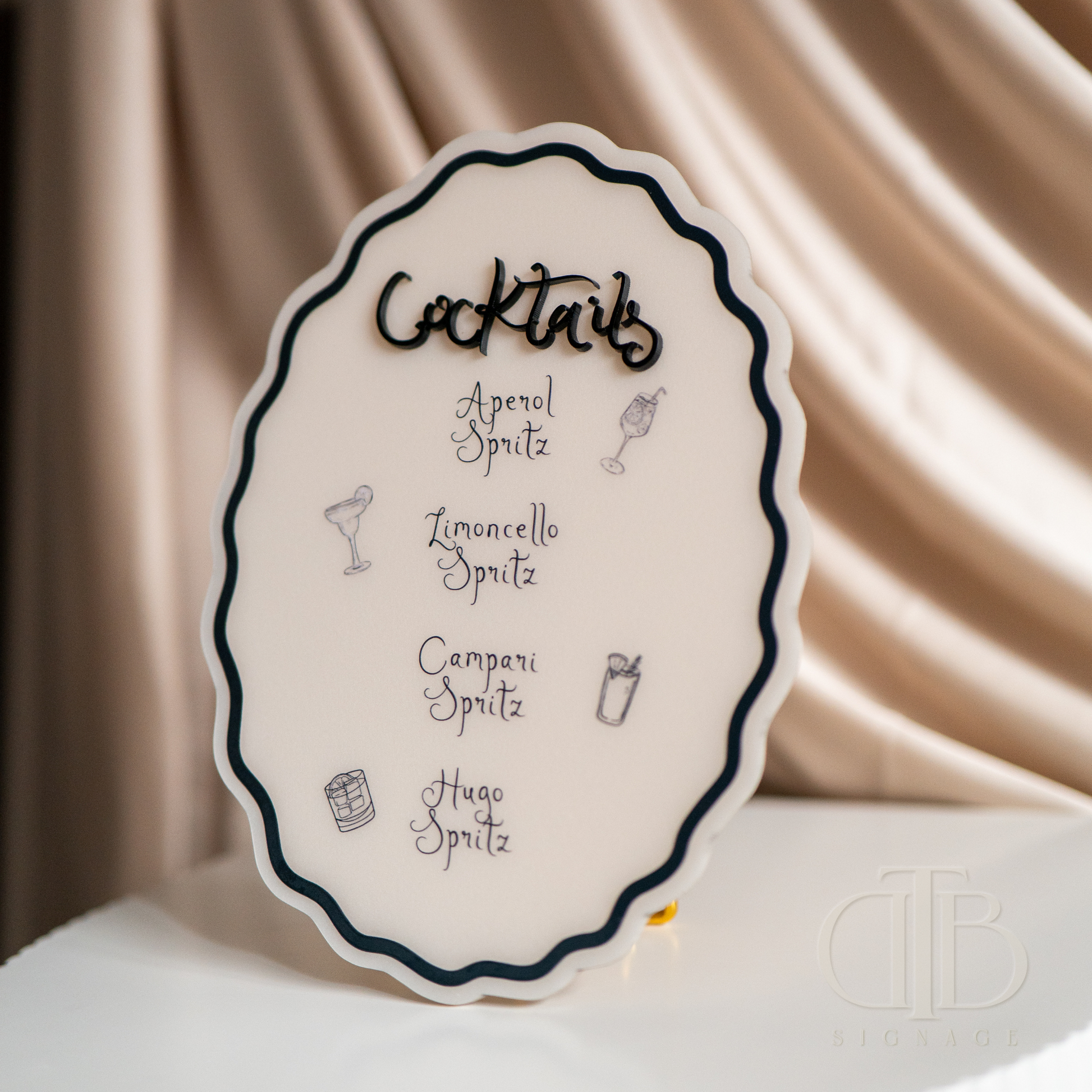 Decorative sign with cocktail names on a satin background