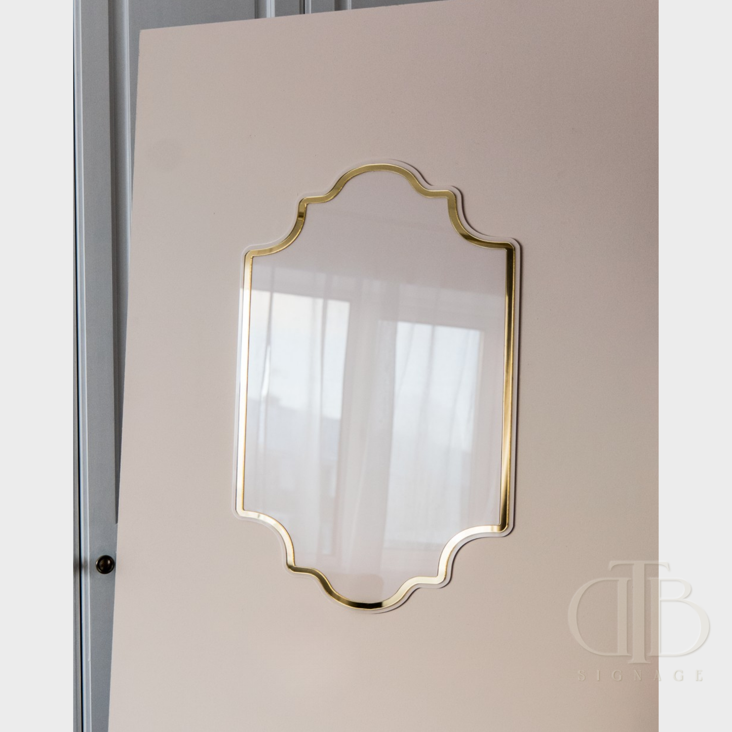 Decorative mirror with gold frame on a beige wall