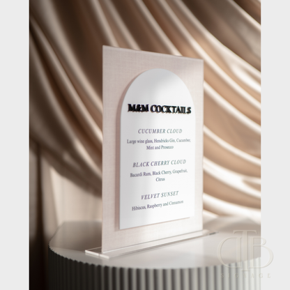 Menu card for M&M Cocktails with cocktail names and descriptions against a textured wall.