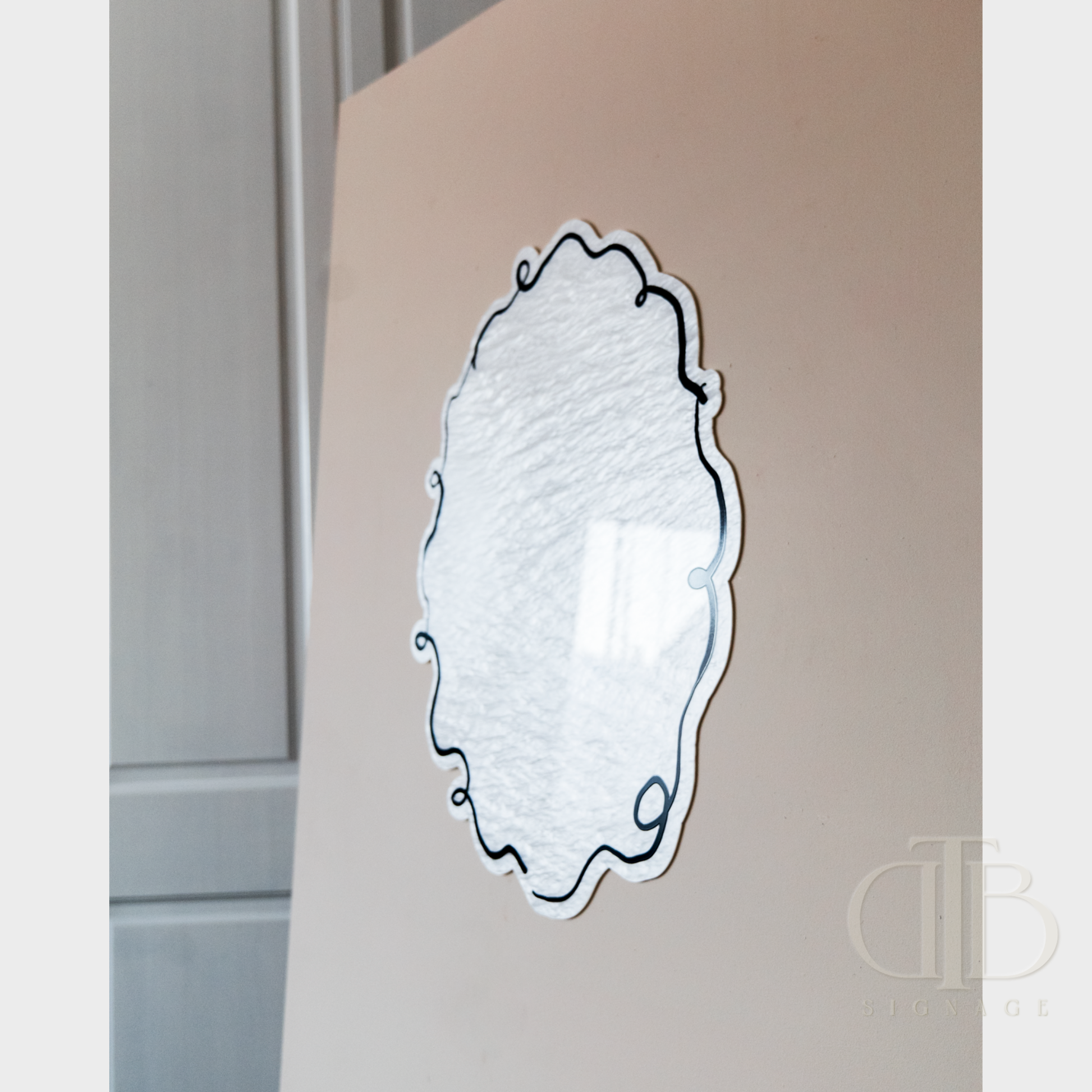 Decorative wall mirror with intricate design on a neutral background