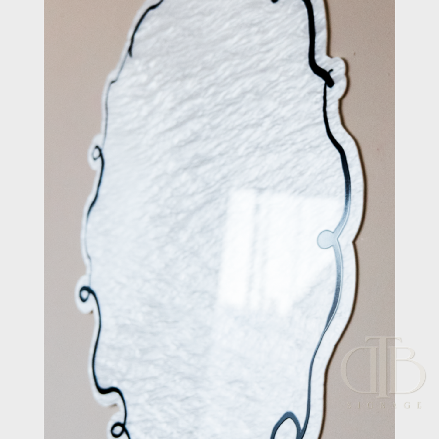 White decorative mirror with black frame on a beige background