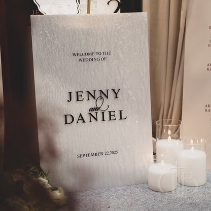 Wedding welcome sign with 'Jenny & Daniel' and candles in the foreground