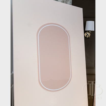 Decorative wall panel with an oval cutout and light fixture in a room setting