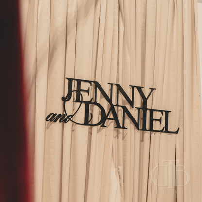 Wooden plaque with 'Jenny and Daniel' engraved on a wooden background