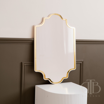 Decorative wall mirror with gold frame on a neutral background