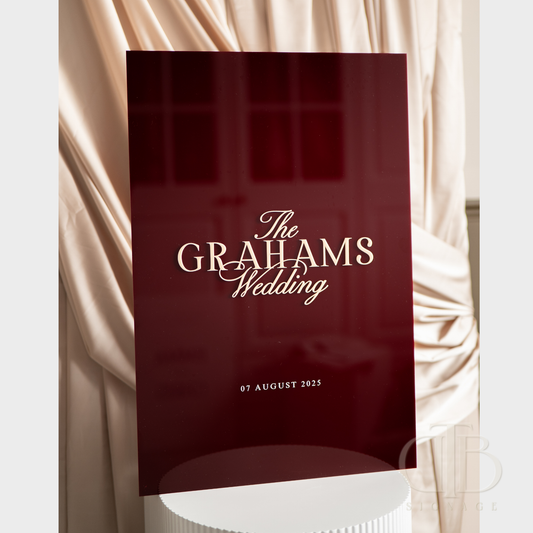 Red wedding invitation with 'The Grahams Wedding' text against a draped fabric background