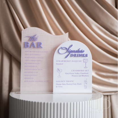 Two menu boards for 'The Bar' and 'Signature Drinks' against a beige curtain background.