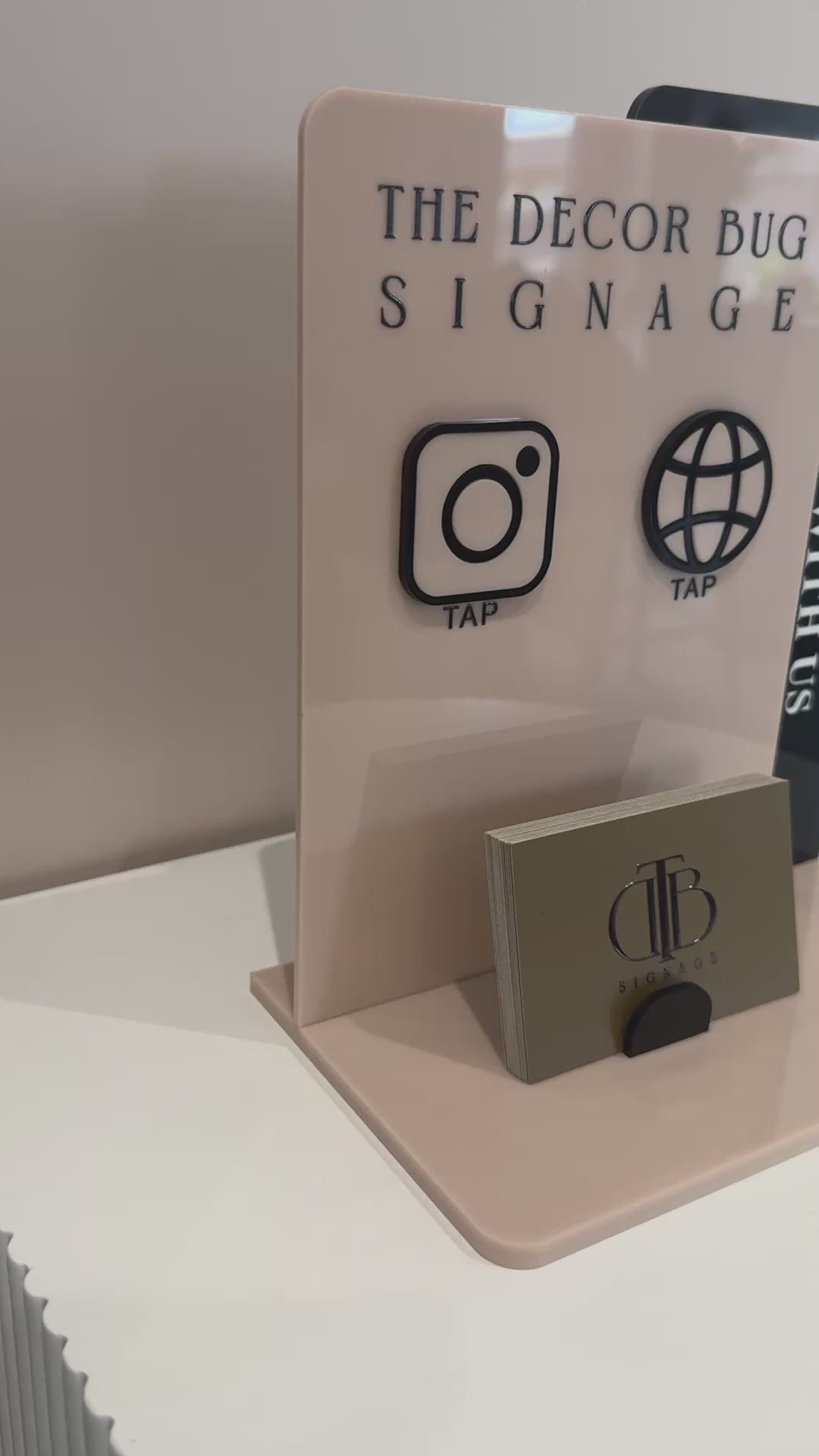 Video clip of Customisable Social Media Board with Whatsapp and Instagram icons with NFC tap technology on a white surface, also have a slot of holding Business Cards, fully made of premium acrylics. Consists o double acrylic board style.