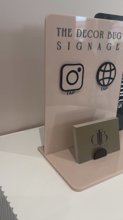 Video clip of Customisable Social Media Board with Whatsapp and Instagram icons with NFC tap technology on a white surface, also have a slot of holding Business Cards, fully made of premium acrylics. Consists o double acrylic board style.